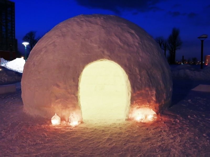 Illuminated snow igloo lit up at night